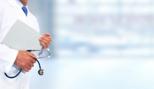 Hands of medical doctor with clipboard. Health care background.